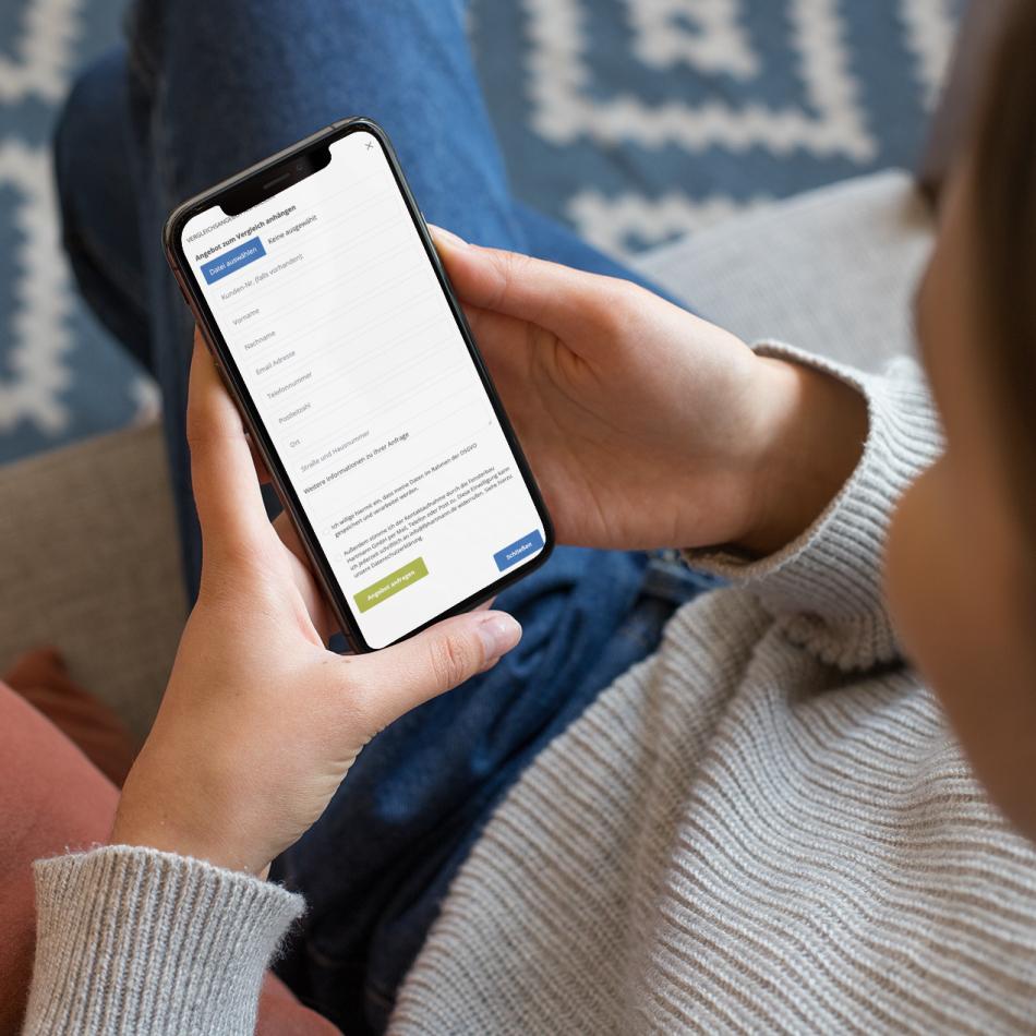 Person hält Smartphone in der Hand und nutzt das einfache Online-Formular von Fensterbau Hartmann zur schnellen Angebotseinholung.