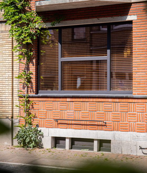 Backsteinhaus mit großem Aluminiumfenster.